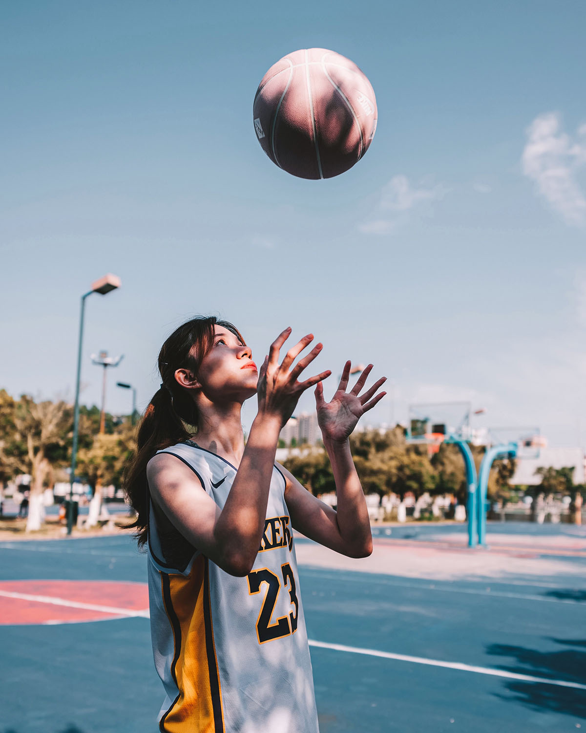 zdjęcie dziewczyny podrzucającej piłkę do koszykówki